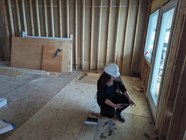 An architectural designer draftsperson on the Gienapp Architects team using a Matterport scanner inside a building being renovated.