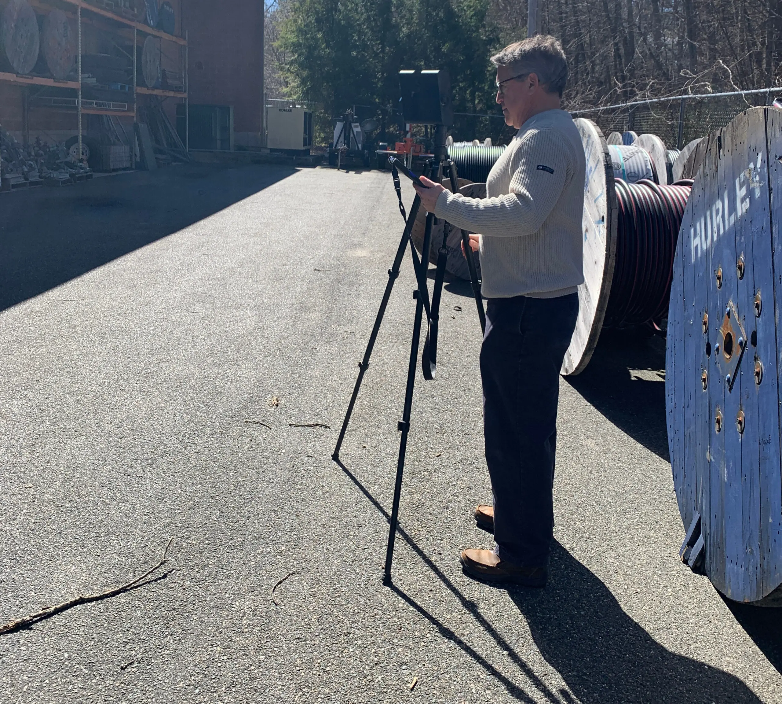 An engineer on the Gienapp Architects team using a Matterport scanner outside of a building.